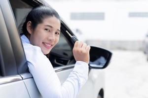 Salesman is carrying the car keys delivered to the customer at the showroom with a low interest offer. Special promotion photo