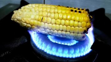 Fresh grilled or roasted corncobs on gas stove flame photo