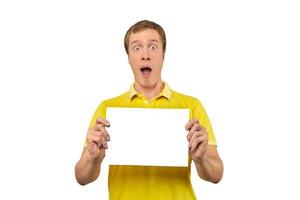 Surprised young man holding blank paper sheet, paper mockup isolated on white background photo