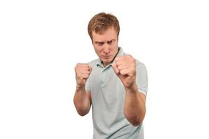 Angry young man in mint T-shirt ready to fight with fists isolated on white background photo