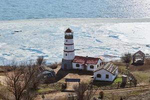 hermoso faro rojo blanco con casas de servicios agrícolas en merzhanovo, rostov en la región de don russia foto