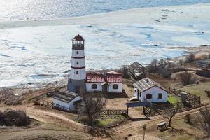 hermoso faro rojo blanco con casas de servicios agrícolas en merzhanovo, rostov en la región de don russia foto