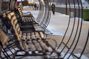 Wooden benches in lantern light in winter city park photo