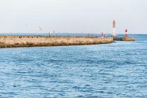 Jetty with towers and buoys. Beautiful seascape, copy space. Breakwater for protect ships at shipyard from waves photo