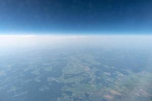 Airplane window view to cloudy sky and earth. Beautiful landscape from aircraft cabin. Flying without fear of flying, incidents and turbulence. photo