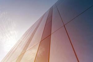 Mirror wall design of shopping center, copy space. Bottom view to modern texture of exterior decoration. Contemporary pattern of buildings. Looking up. photo