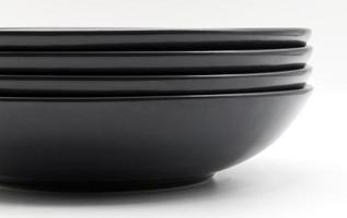 Stack of black dishes isolated on white background photo
