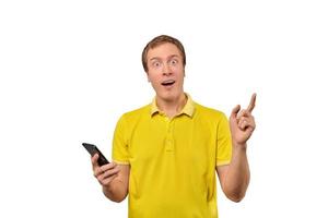joven sorprendido con smartphone, tipo gracioso sosteniendo teléfono aislado de fondo blanco foto