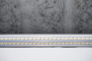 Strip LED light with aluminum profile on stretch ceiling, close up. Home renovation concept photo