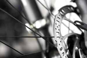 Bicycle disk brakes close up, metal disc attached to bike wheel, effective mountain bicycle brakes photo