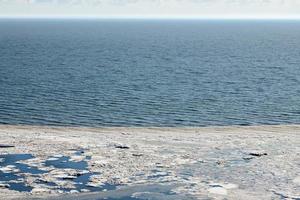 Melting sea ice seasonal natural phenomenon of coming spring, ice on water melts from burning sun photo
