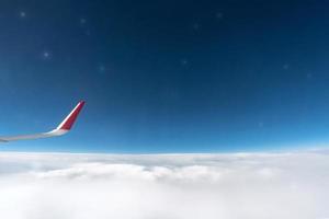 vista de la ventana del avión al cielo nublado y las estrellas. hermoso cielo desde la cabina del avión. volando sin incidentes ni turbulencias. foto