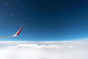 Airplane window view to cloudy sky and stars. Beautiful sky from aircraft cabin. Flying without incident and turbulence. photo