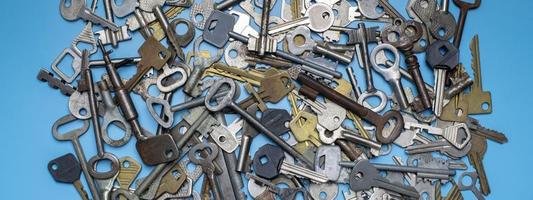 Keys set on blue background. Door lock keys and safes for property security and house protection. Different antique and new types of keys. photo