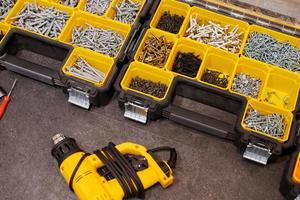 Storage boxes on floor with screws, nuts, bolts, nails and other small tools for handyman, close up photo