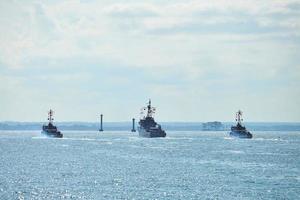 Three battleships war ships during parade and naval exercises maneuvering in bright blue sea photo