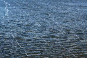 contaminación de la línea de espuma en el río. emisiones de aceite de fábrica, contaminación ambiental. río azul profundo con fuerte corriente. foto