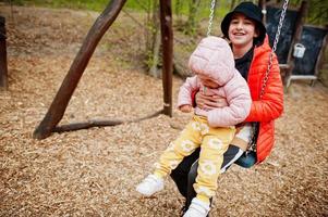 Brother with sister on a swing. photo