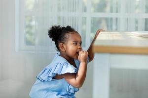 Cute little American girl wearing a blue shirt eats homemade cookies while her parents are away. photo