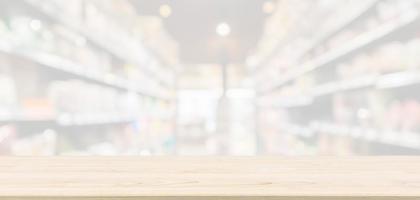 Empty Wood table top with supermarket grocery store aisle blurred defocused background with bokeh light for montage product display photo