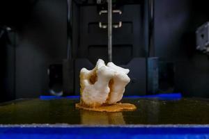 Modern 3D printer printing figure close-up macro 3d printer prints a vertebra photo