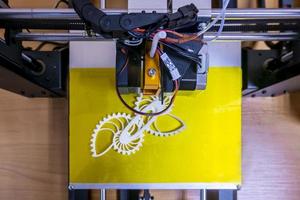 Modern 3D printer printing figure close-up macro 3d printer prints with orange plastic photo