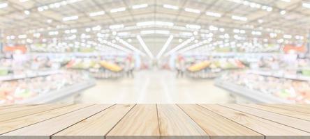 Wood table top with supermarket grocery store blurred defocused background with bokeh light for product display photo