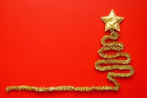 Golden christmas tree on red background new year holiday celebration concept photo