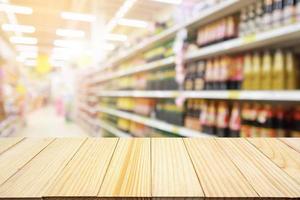 supermarket discount store aisle and product shelves interior defocused abstract blur background with wood table photo