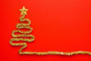 Golden christmas tree on red background new year holiday celebration concept photo