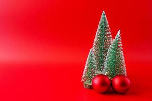 árbol de navidad y adornos sobre fondo rojo concepto de celebración navideña de año nuevo foto