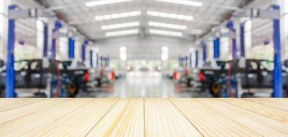 Empty wood table top with car service centre auto repair workshop blurred background photo