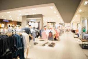 Woman fashionable boutique clothing store window display in shopping mall blur defocused background photo