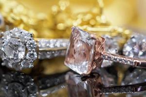 joyas de oro de lujo, diamantes y anillos de topacio rosa con reflejo en el fondo negro foto