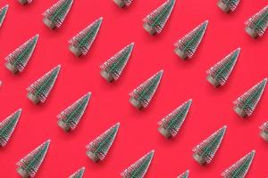 Green Christmas tree pattern minimal flatlay on red background new year holiday celebration concept photo