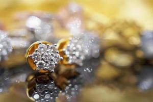 Pendientes de diamantes de joyería de oro de lujo con reflexión sobre fondo negro foto