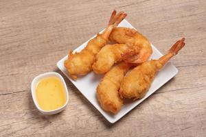 Battered shrimp with plum sauce in white plate photo
