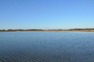 un lago o río con pastos marrones y orilla foto