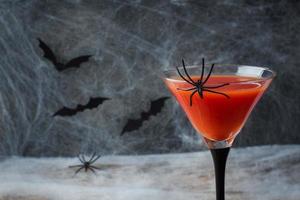 Bloody Mary cocktail, spider web background and bats for Halloween, selective focus photo