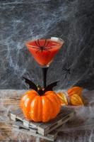 Bloody Mary cocktail, pumpkin with bats and spiders for Halloween, selective focus photo