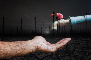 concepto de crisis de escasez de agua dulce debido a cambios ambientales. grifo de agua sin agua corriente sobre un fondo negro hay un espacio de copia. foto