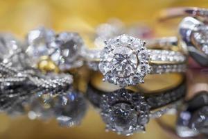 anillos de diamantes de joyería de oro de lujo con reflejo en el fondo negro foto