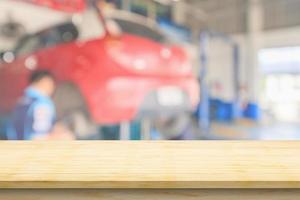 Empty wood table top with car service centre auto repair workshop blurred background photo