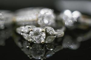 anillos de diamantes de joyería de lujo con reflejo en el fondo negro foto