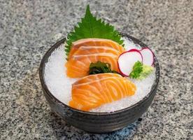 sashimi de salmón sobre hielo en un tazón negro comida japonesa foto