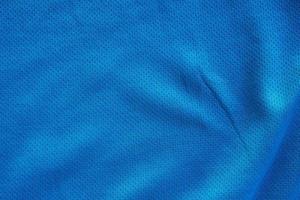 camiseta de fútbol de ropa deportiva de tela azul con fondo de textura de malla de aire foto