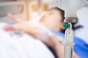 Medical drip with patient in the hospital blurred background photo