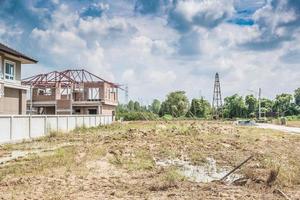 Residential new house building at construction site with clouds and blue sky photo