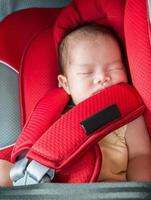 Newborn baby girl sleep in car seat photo