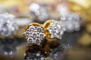 Pendientes de diamantes de joyería de oro de lujo con reflexión sobre fondo negro foto